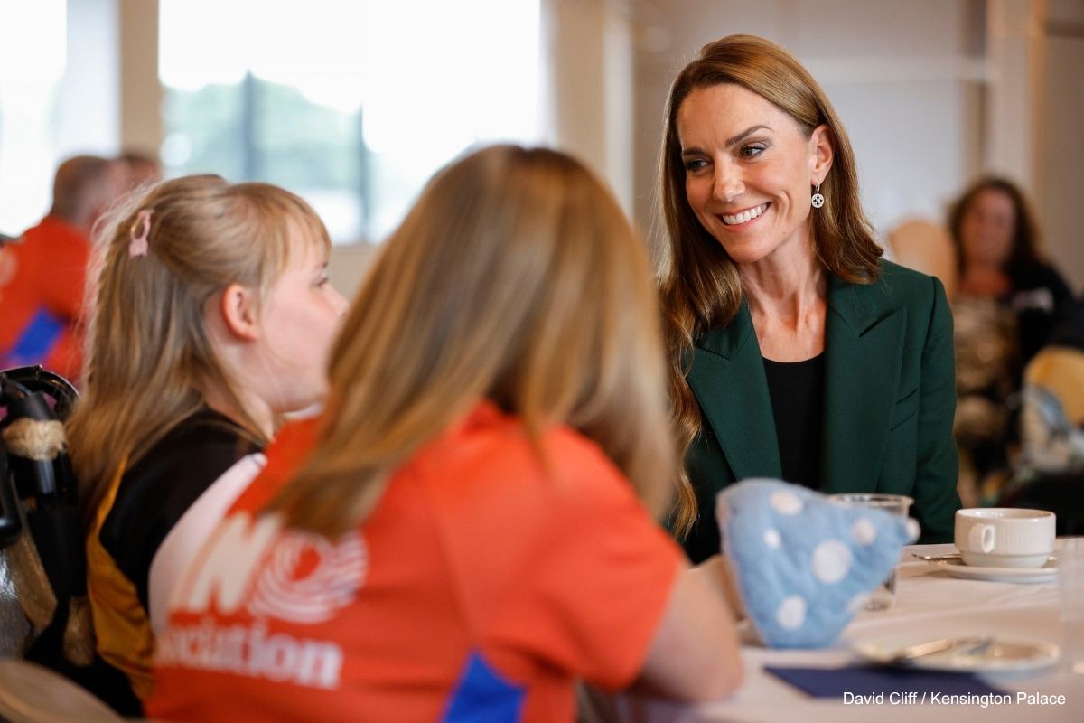 Kate smiles while talking to a young girl in Wakefield
