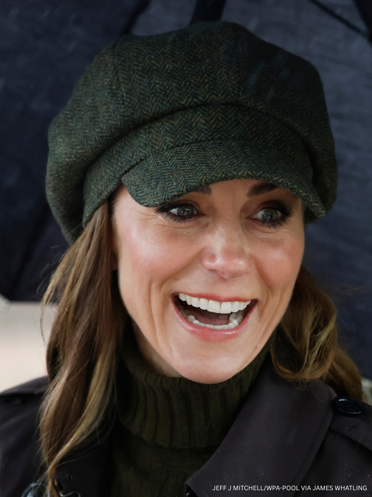 Kate Middleton smiling in a green tweed baker-boy cap and brown Burberry coat on the Isle of Bute