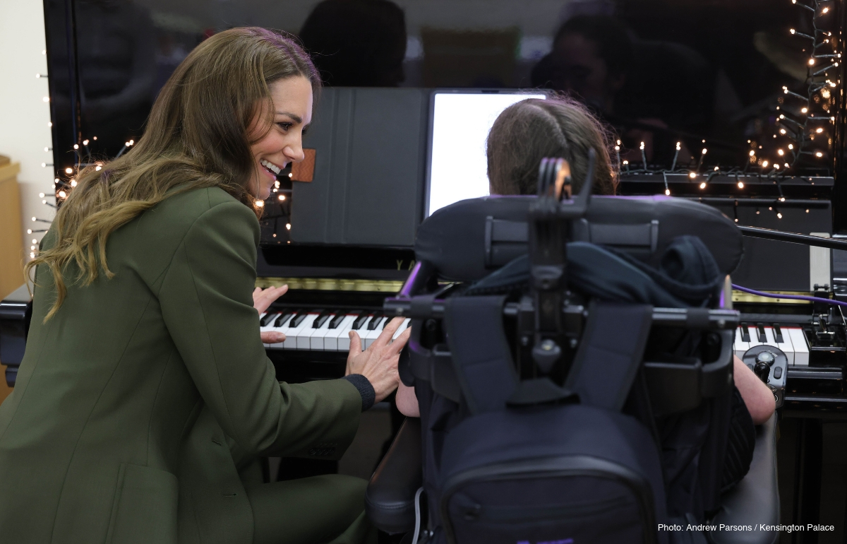 Kate Middleton beside a child at a keyboard during a music session at The Treehouse