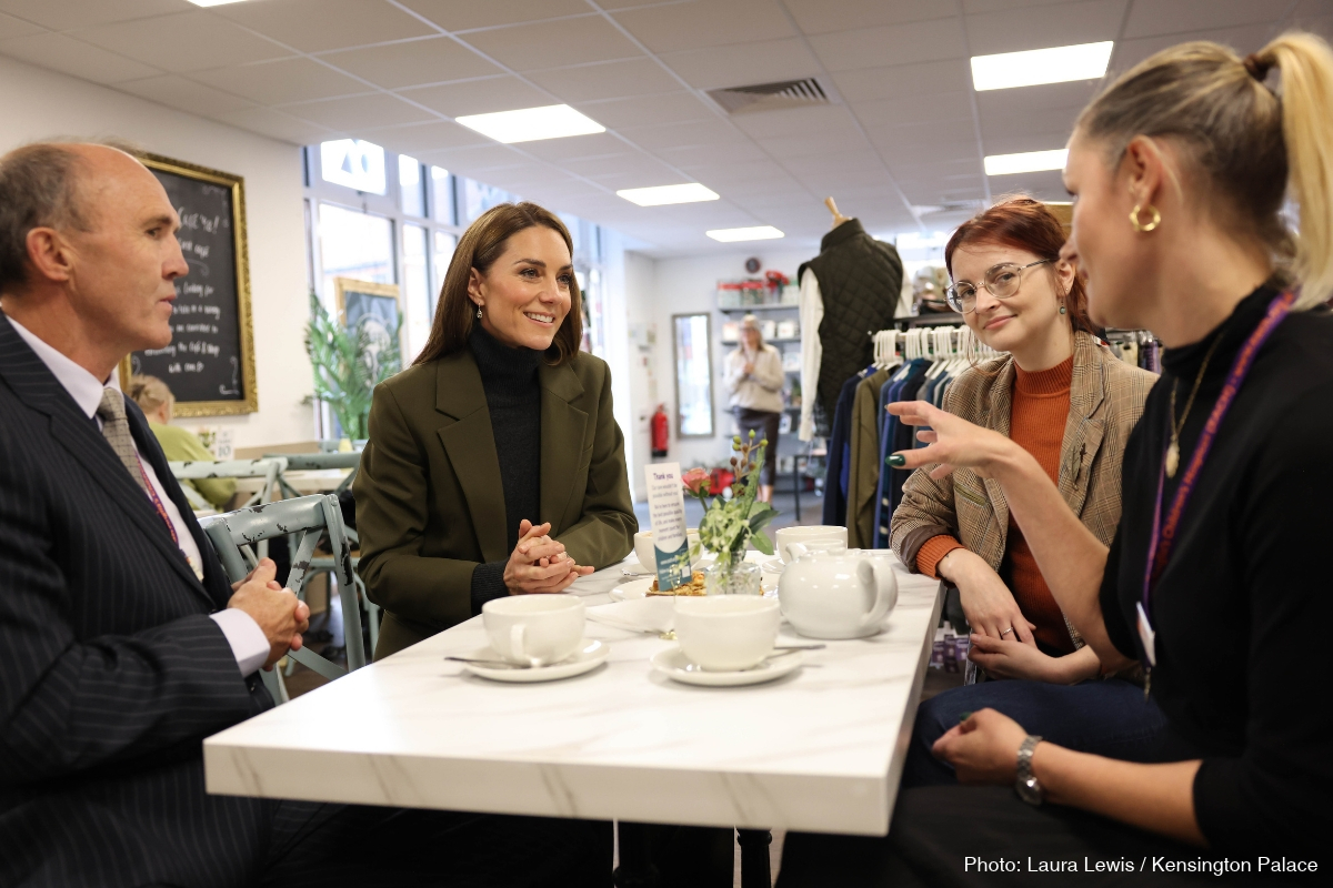 Kate Middleton seated at a table chatting over coffee at Café 98