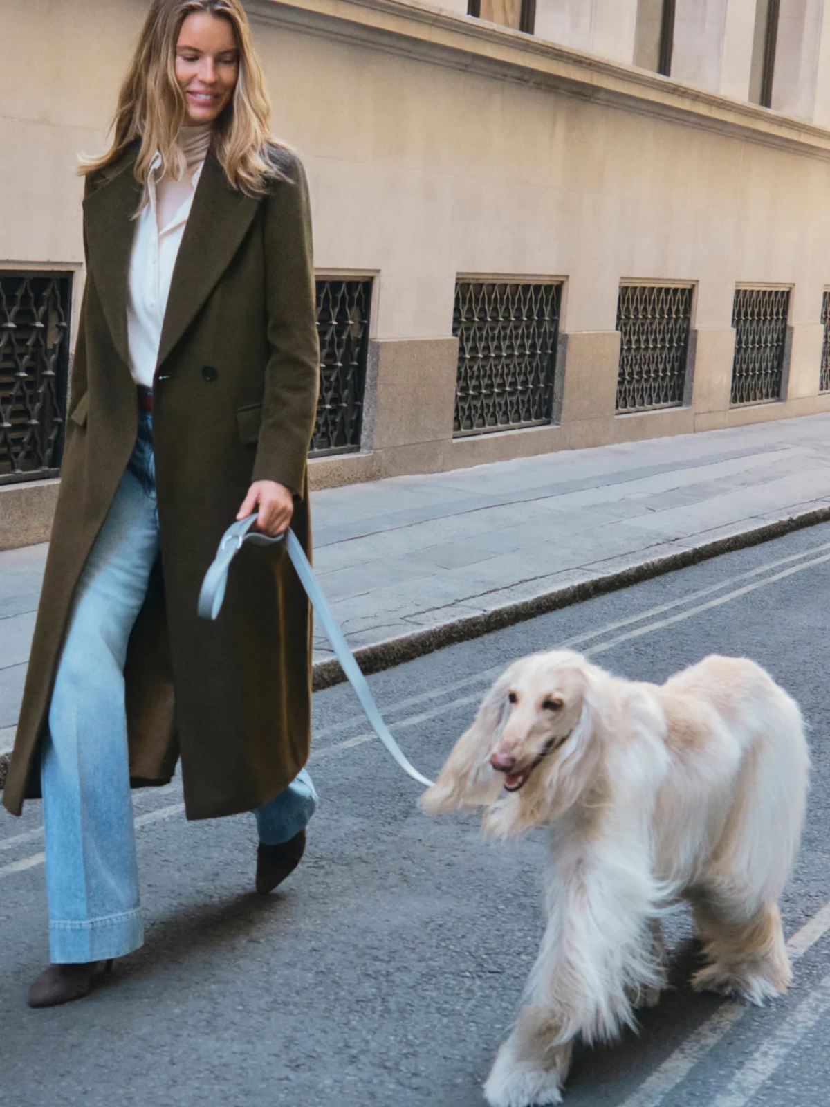 Model wearing the Jigsaw Wool Maxi City Coat in khaki while walking a dog