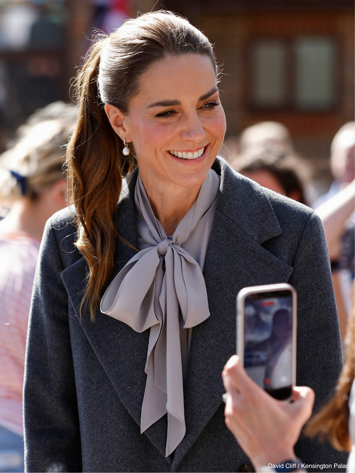 Kate Middleton in a charcoal coat and grey bow blouse during her West Sussex Minibus Service visit