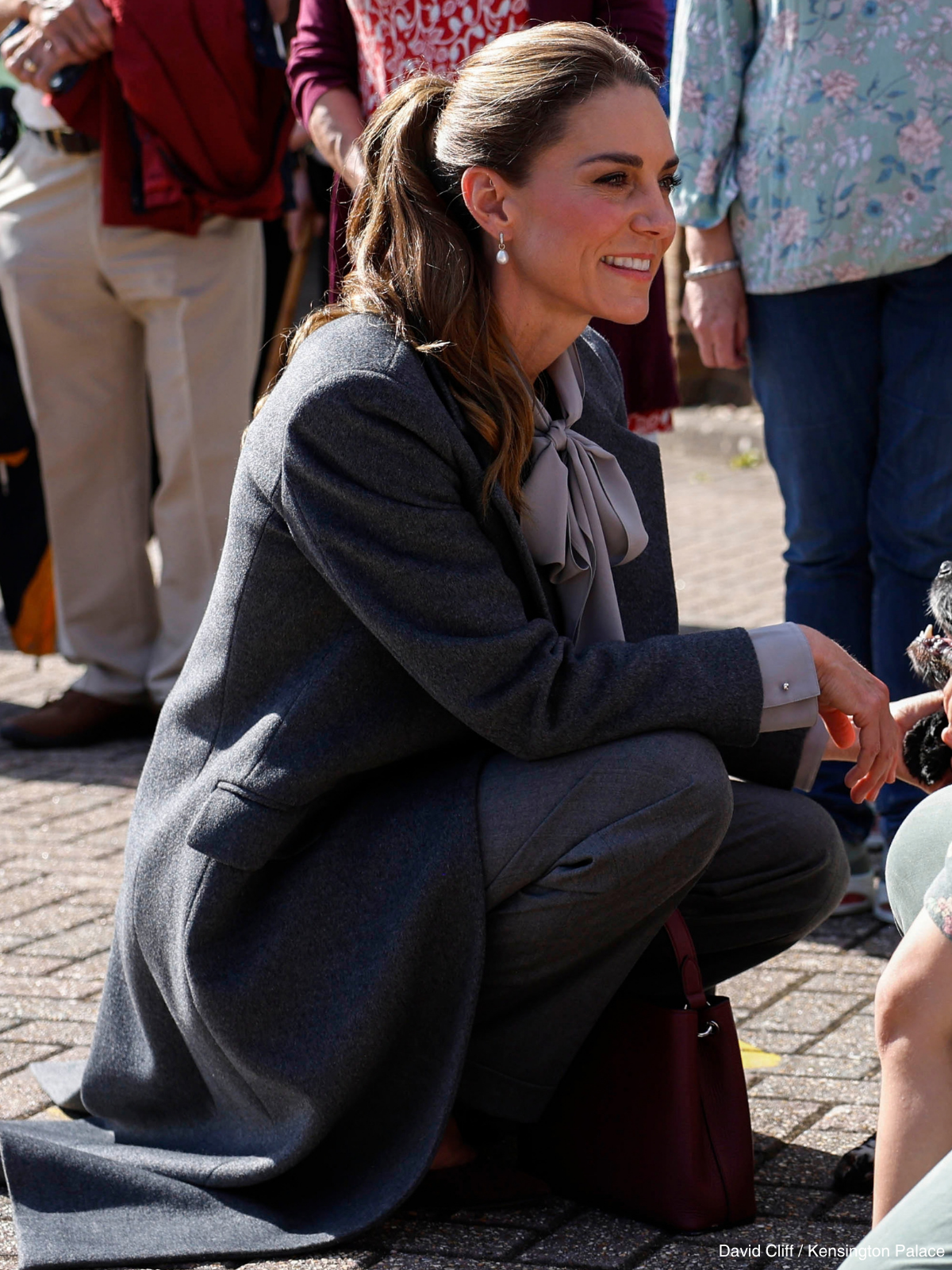 Kate Middleton crouching to speak to people gathered outside Pulborough Village Hall