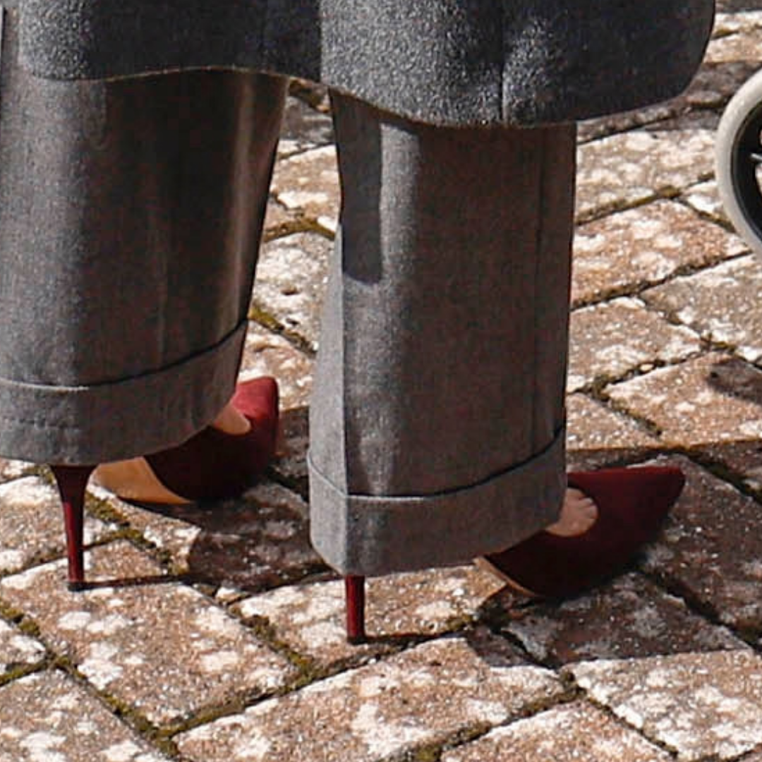 Close-up of Kate’s burgundy suede heels beneath her grey turned-up trousers