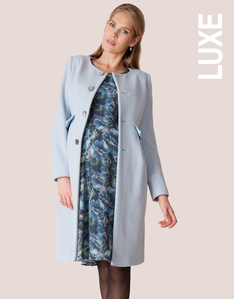 Seraphine model wearing the Florrie Floral Print Dress and the Natasha coat in blue.