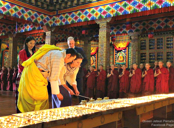 The two royal couples light butter lamps