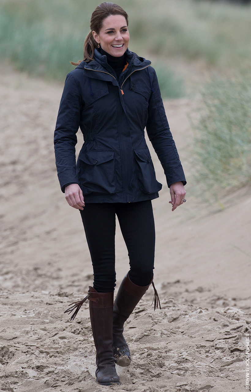 Kate Middleton wearing the navy blue Troy London wax parka on a beach in Wales, May 2019.