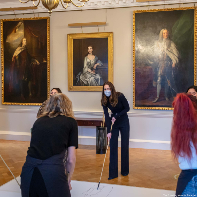 Kate Middleton takes part in an activity inside the Foundling Museum in London.  She's wearing a black outfit.