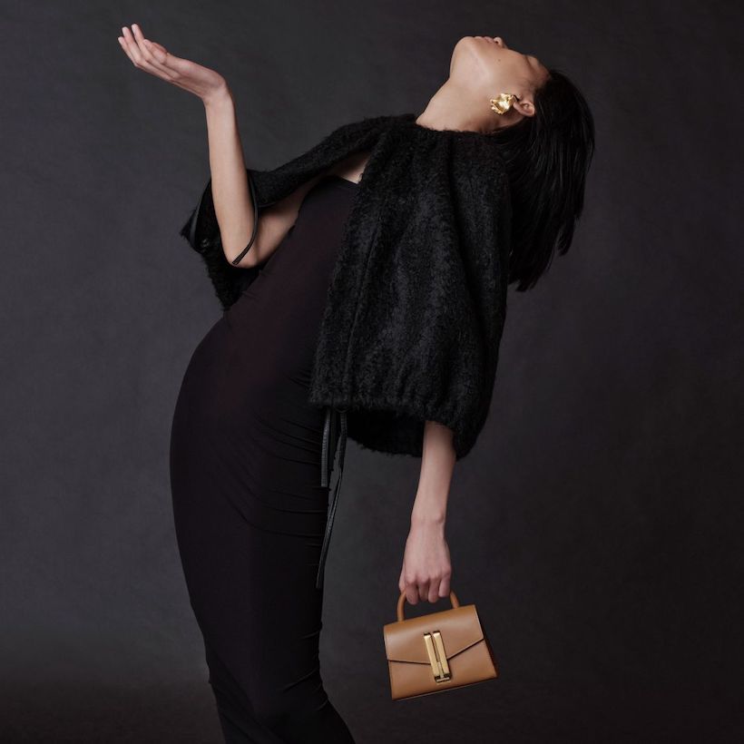 Model carrying the Nano Montreal bag in toffee.  Model is dressed in black eveningwear. 