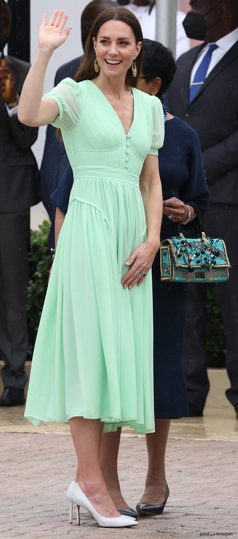 Kate Middleton in the Bahamas, waving. She's wearing a green dress by Self Portrait and white shoes by Jimmy Choo