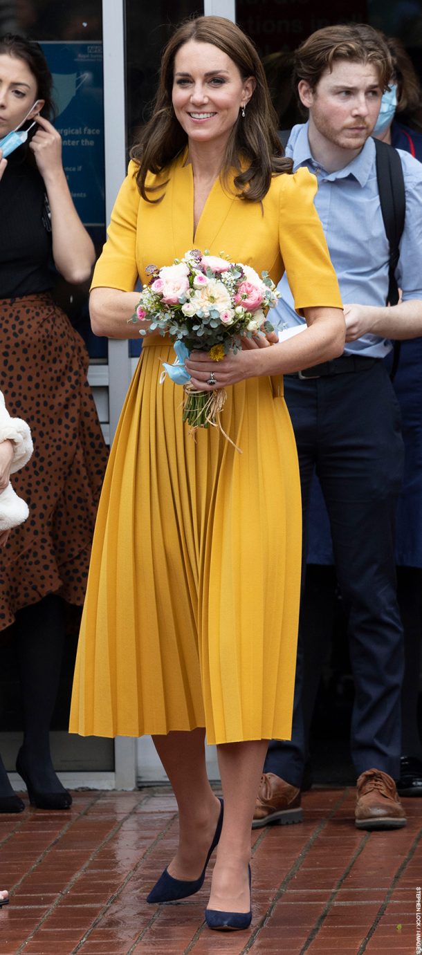 Kate Middleton wearing a yellow dress visiting the Royal Surrey County Hospital today