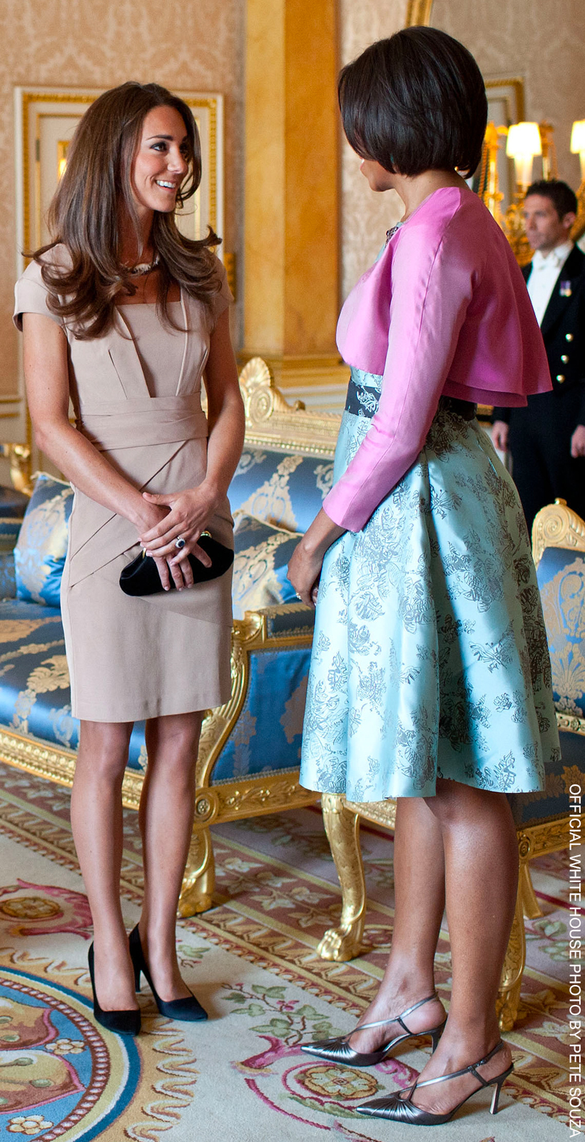 Princess Kate in a beige knee-length dress, speaking to Michelle Obama. 