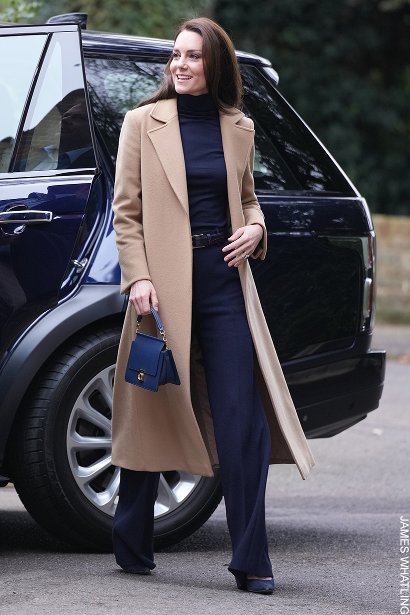 Kate Middleton visiting a nursing home in Oxford wearing her camel coat by Max and Co. She's paired the coat with a navy outfit.