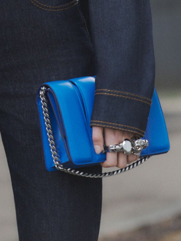 Model holding an Alexander Mcqueen handbag.