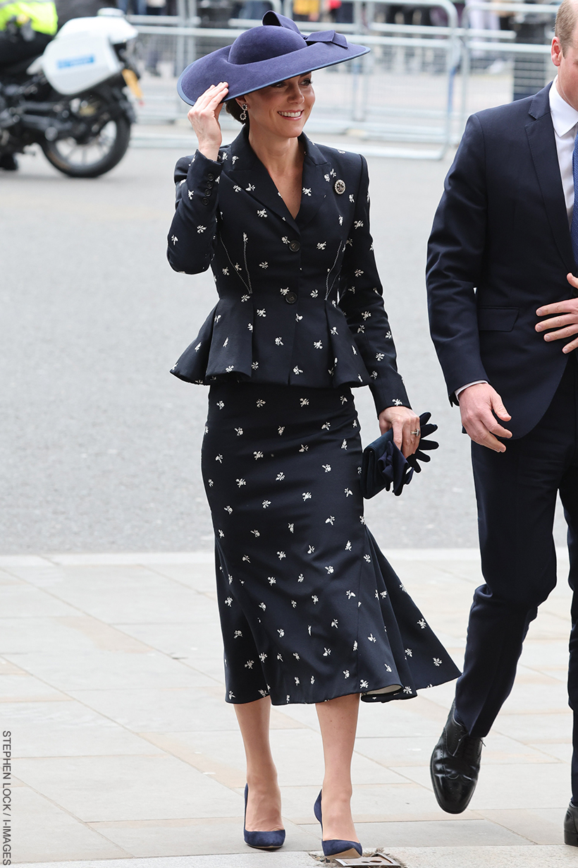Kate Middleton wearing a navy peplum jacket and fluted skirt—both decorated in flowers—for the Commonwealth Service