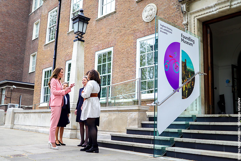 Kate Middleton enters the Foundling Museum. She's wearing a pink suit with pearl accessories. 