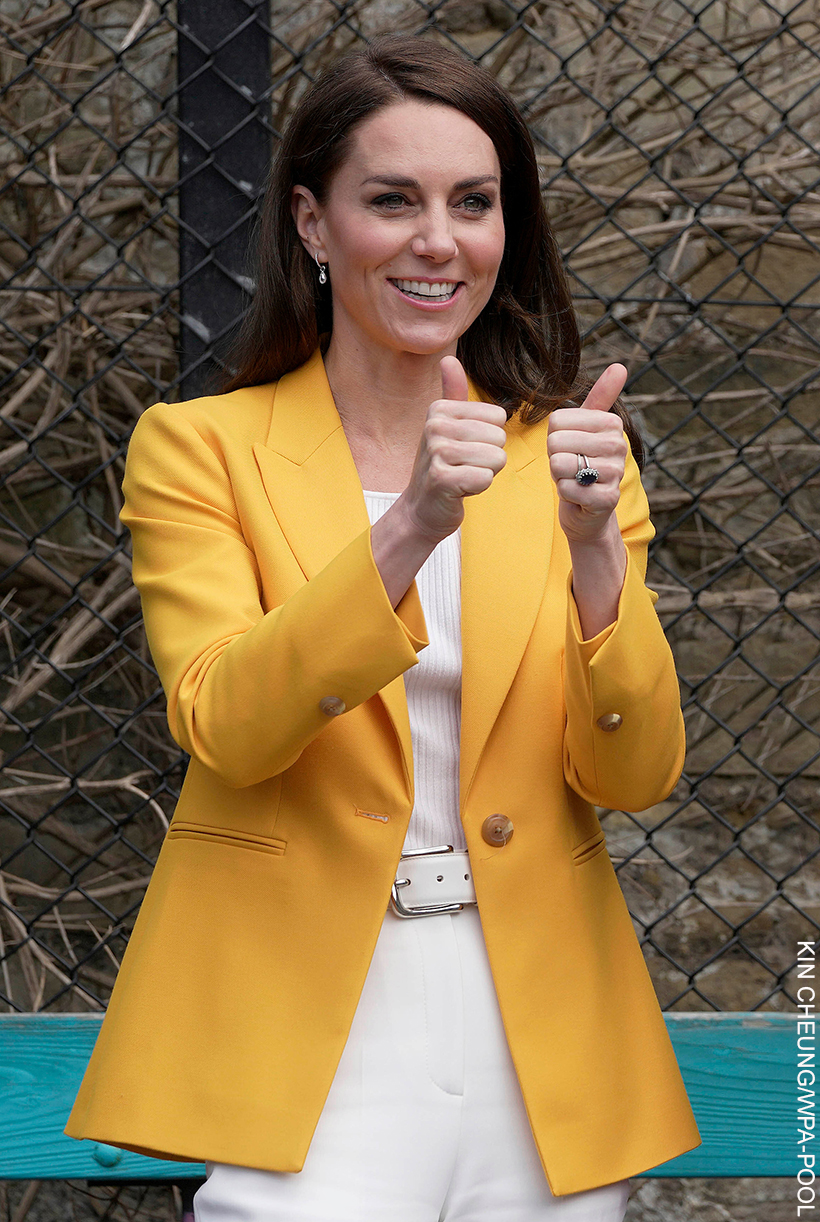 Kate Middleton giving a thumbs up as she wears her bright yellow blazer.