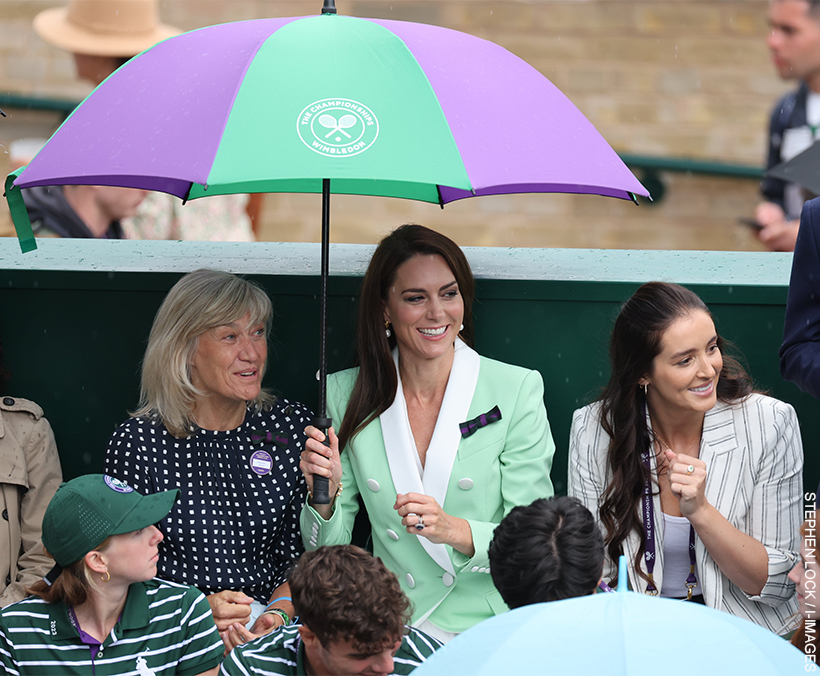 Kate Middleton sits under an umbrella during Wimbledon, as rain distrupts play