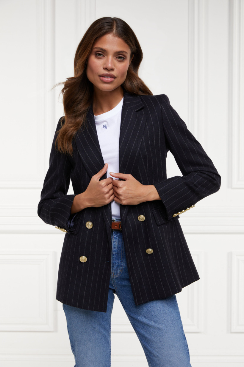 Model shot of the tailored pinstripe blazer in navy, which features gold buttons