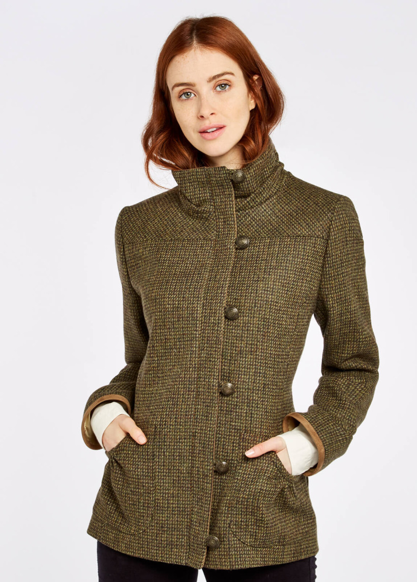 Model wearing the tweed jacket, which features a stand up collar and buttons along the front, offset to the side.