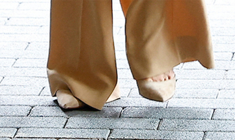 Close up detail showing Kate's feet, and her wearing the pointed biscuit coloured heels