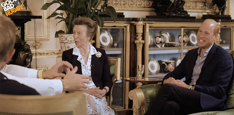 Princess Anne and Prince William chatting to the podcast hosts, laughing and looking animated. 