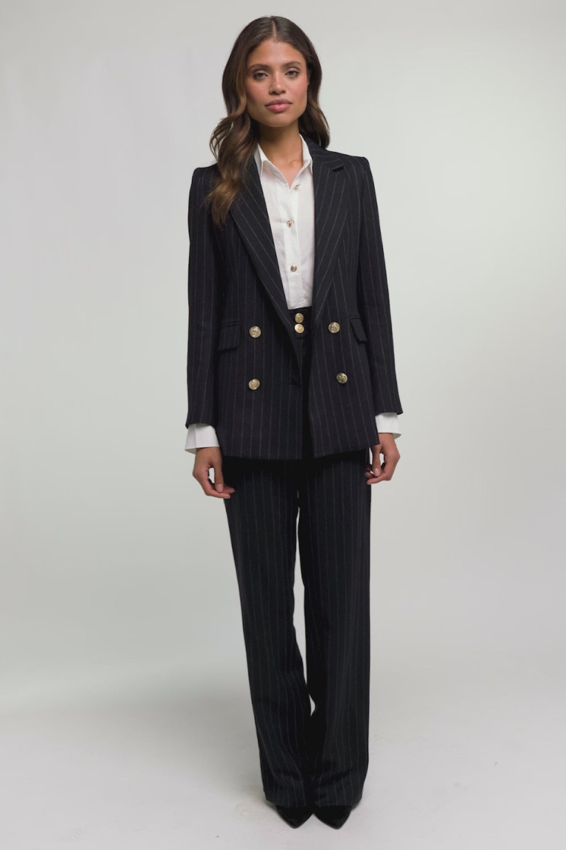 Model shot of the tailored pinstripe suit in navy, which features gold buttons
