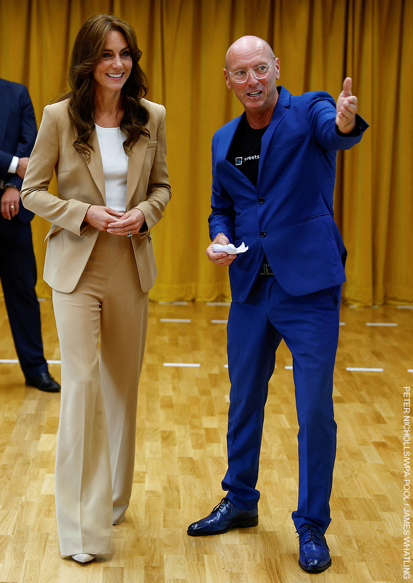 The Princess of Wales in her beige/camel suit.  She stands next to the charity's founder who wears a bright blue suit.