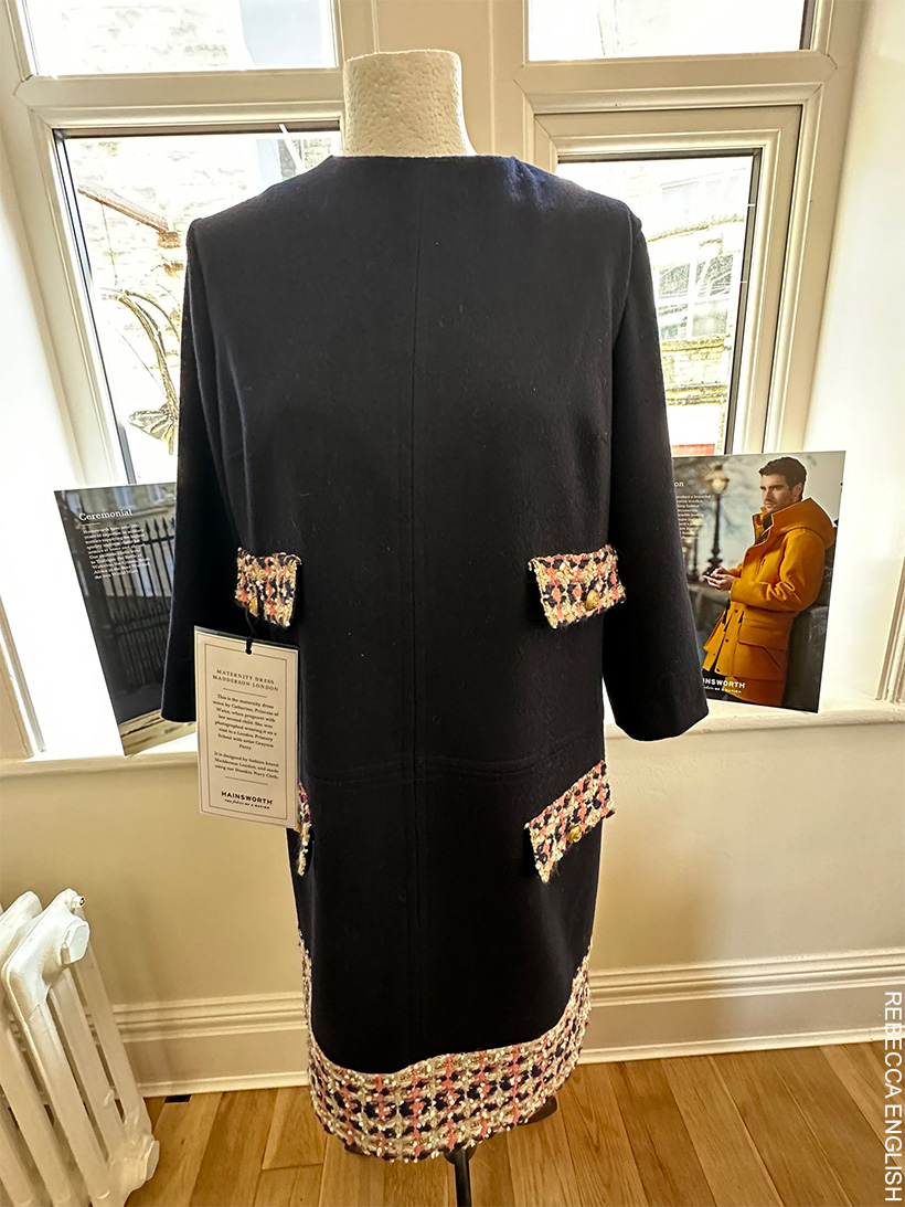 A navy blue Maternity dress with tweed pocket flaps and tweed hem, on a mannequin.  