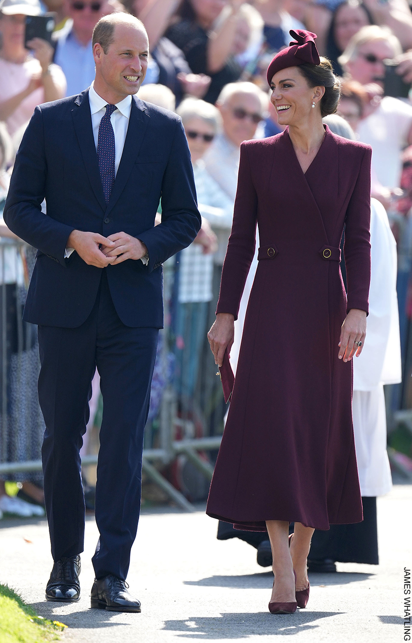 William and Kate in St David's, Wales. The Princess is wearing a long burdgundy coat dress, matching hat and matcihng accesoris.