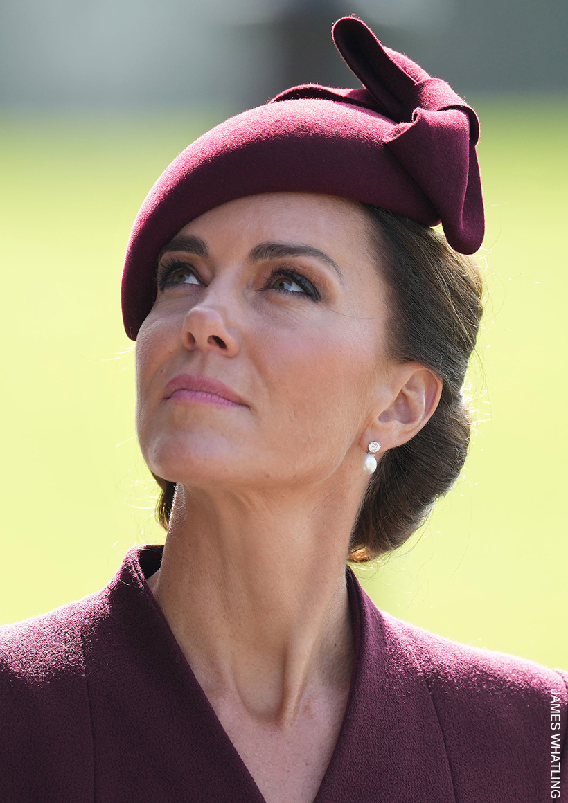 The Princess of Wales wearing a burgundy bow-topped hat, and the late Queen Elizabeth's pearl earrings.