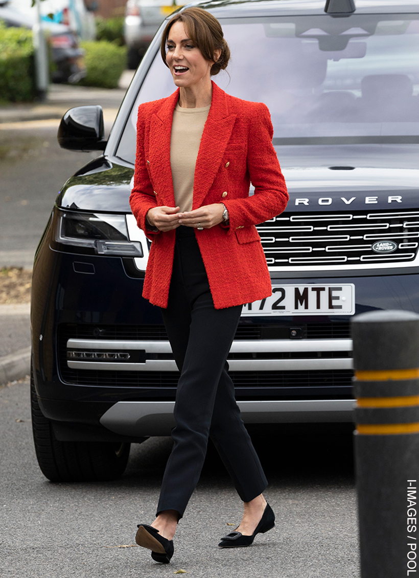 Kate Middleton walks towards the children's centre wearing a red blazer from Zara and black pointed flat shoes from Boden.