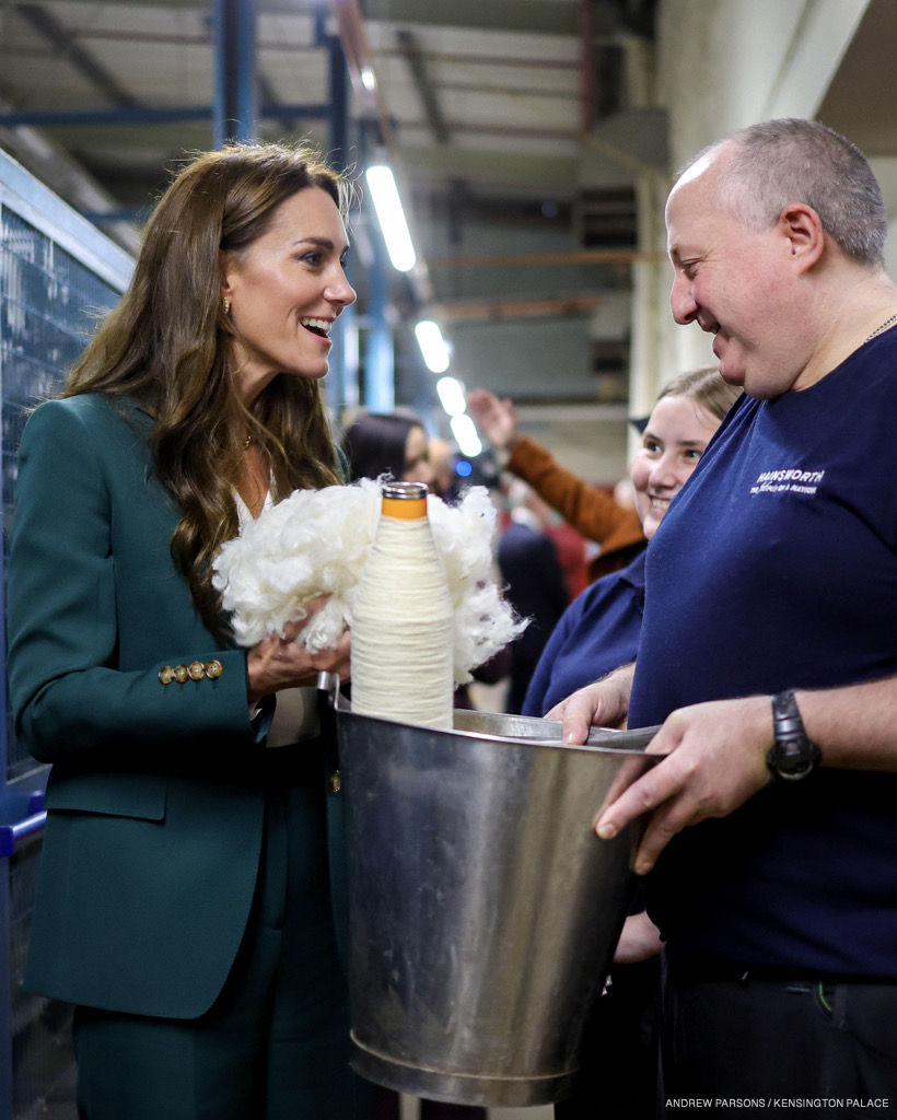 The Princess looking animated, chatting to workers, while holding a handful of wool. 