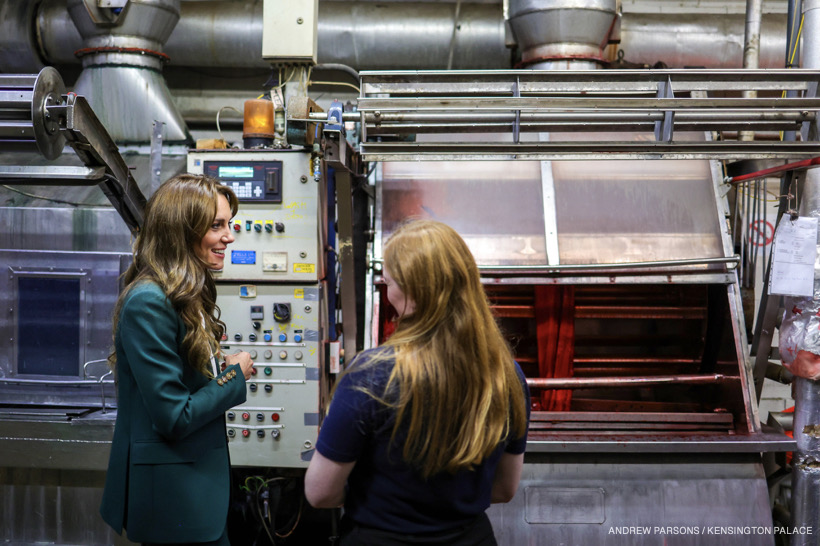 Kate speaking with workers at the factory.