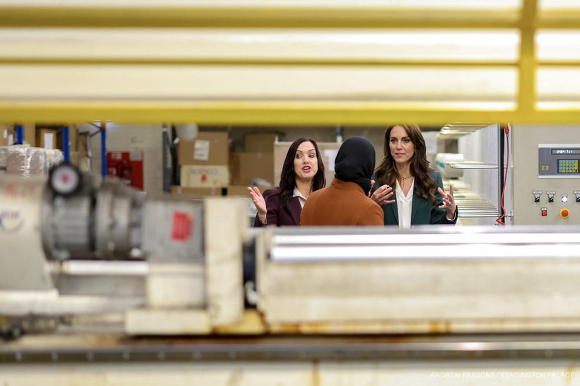 Kate speaking with workers at the factory. 