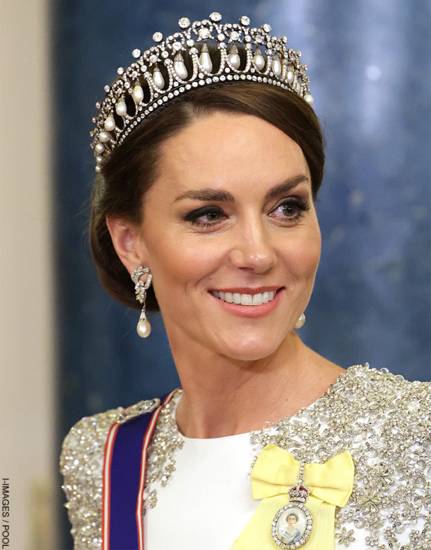 Kate Middleton smiling, wearing a tiara, pearl earrings and white dress with crystal detail at the South Africa State Banquet in 2022