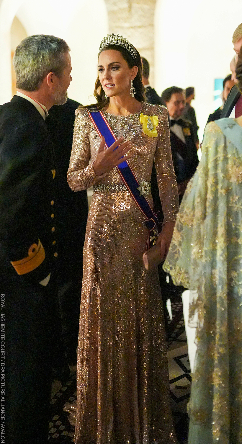 Kate Middleton chatting with guests at the Jordan Royal Wedding in 2023.  She wears the Queen Mary Lover's Knot Tiara with a shimmering pink gown.