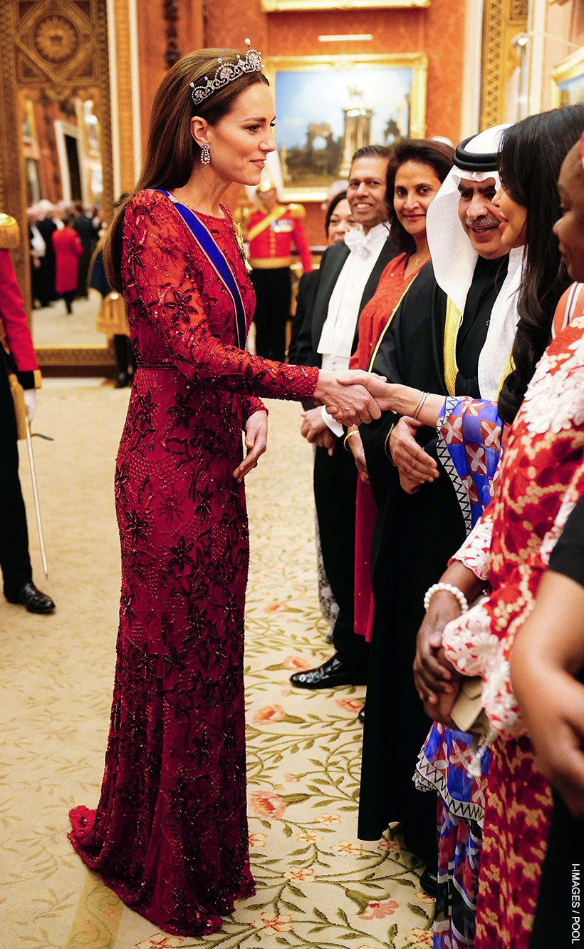 Kate Middleton greeting guests, wearing the Lotus Flower tiara, chandelier earrings and red dress with crystal details at the 2022 Diplomatic Corps Reception.