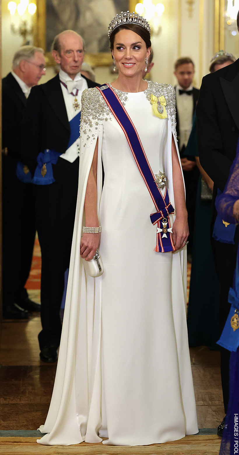 Kate Middleton smiling, wearing a tiara, pearl earrings and white dress with crystal detail at the South Africa State Banquet in 2022