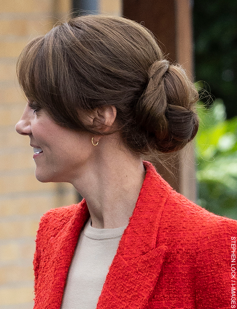 Kate Middleton's hair is in a chic up-do.  You can also see her gold hoop earrings.