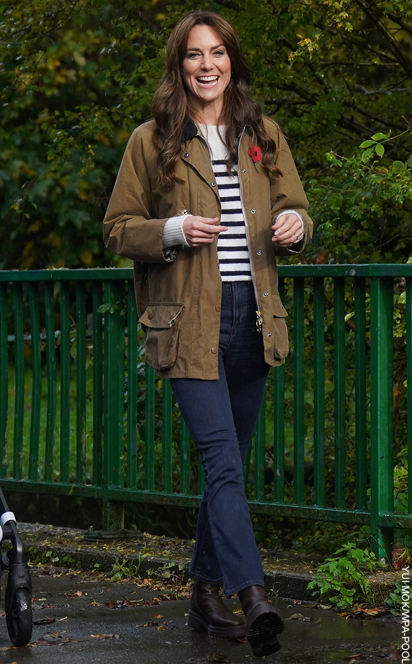 The Princess of Wales showcasing a casual yet polished ensemble. She dons a pair of classic dark blue jeans paired with a practical and stylish khaki jacket, ideal for a crisp autumn day. Underneath the jacket, a hint of a striped jumper peeks through, adding a dash of pattern to the look. Completing the outfit, she opts for a pair of robust brown boots, perfect for a day of outdoor activities. The look embodies casual elegance with a focus on comfort and practicality.