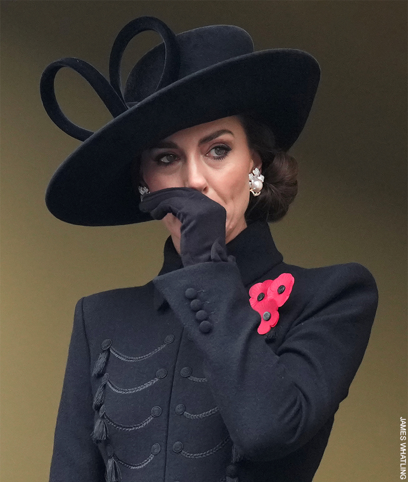 A candid shot  of Kate Middleton in a black coat and hat, lifting her gloved hand gracefully to her face.

