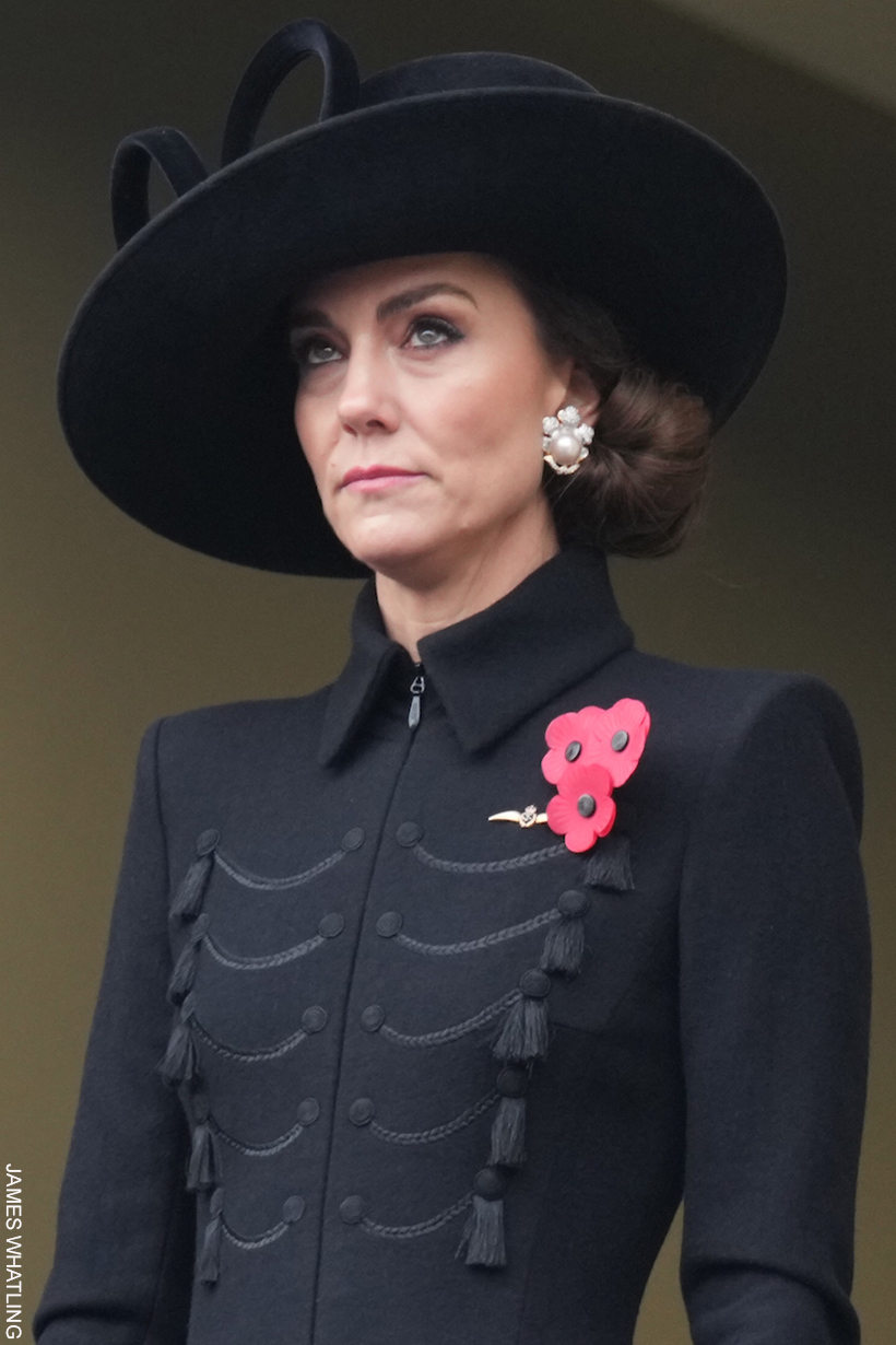 Kate Middleton looking dignified in a structured, dark coat adorned with a red poppy brooch, with intricate rope-like details and tassel motifs, stands against a sombre background, her expression contemplative.