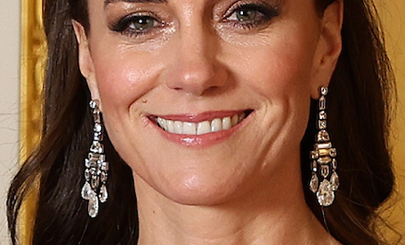 A close-up of Kate Middleton accessorising her pink gown with intricate Cartier chandelier earrings featuring various diamond cuts.