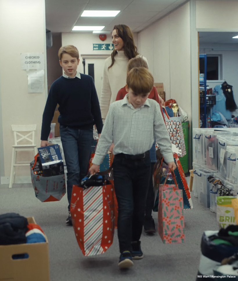 Kate and the kids carry the gift bags they've packed to another room