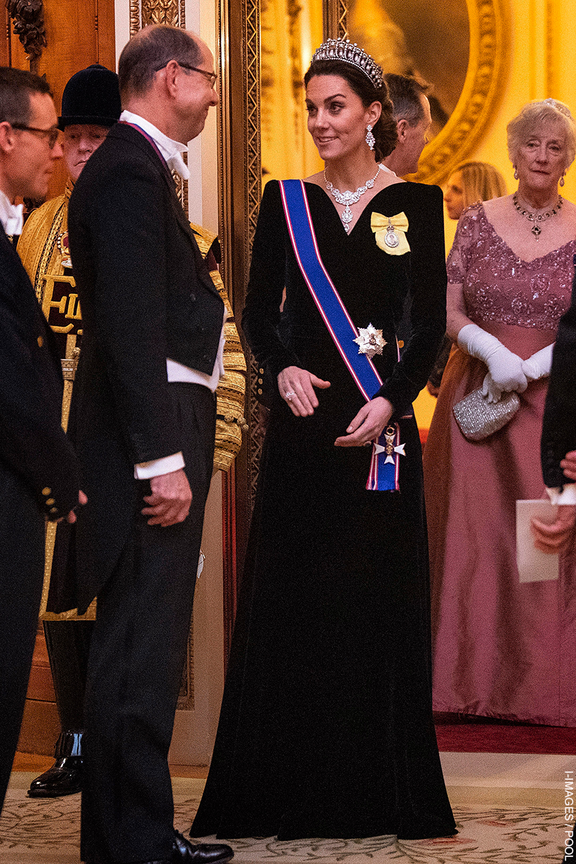 Princess Kate at a royal engagement, dressed in a navy velvet gown by Alexander McQueen, featuring the Royal Victorian Order sash and Lover's Knot Tiara