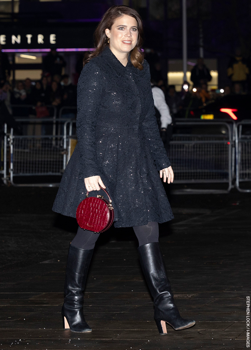 Princess Eugenie, in a black coat and black boots, walking into the 2023 Together At Christmas Carol Concert