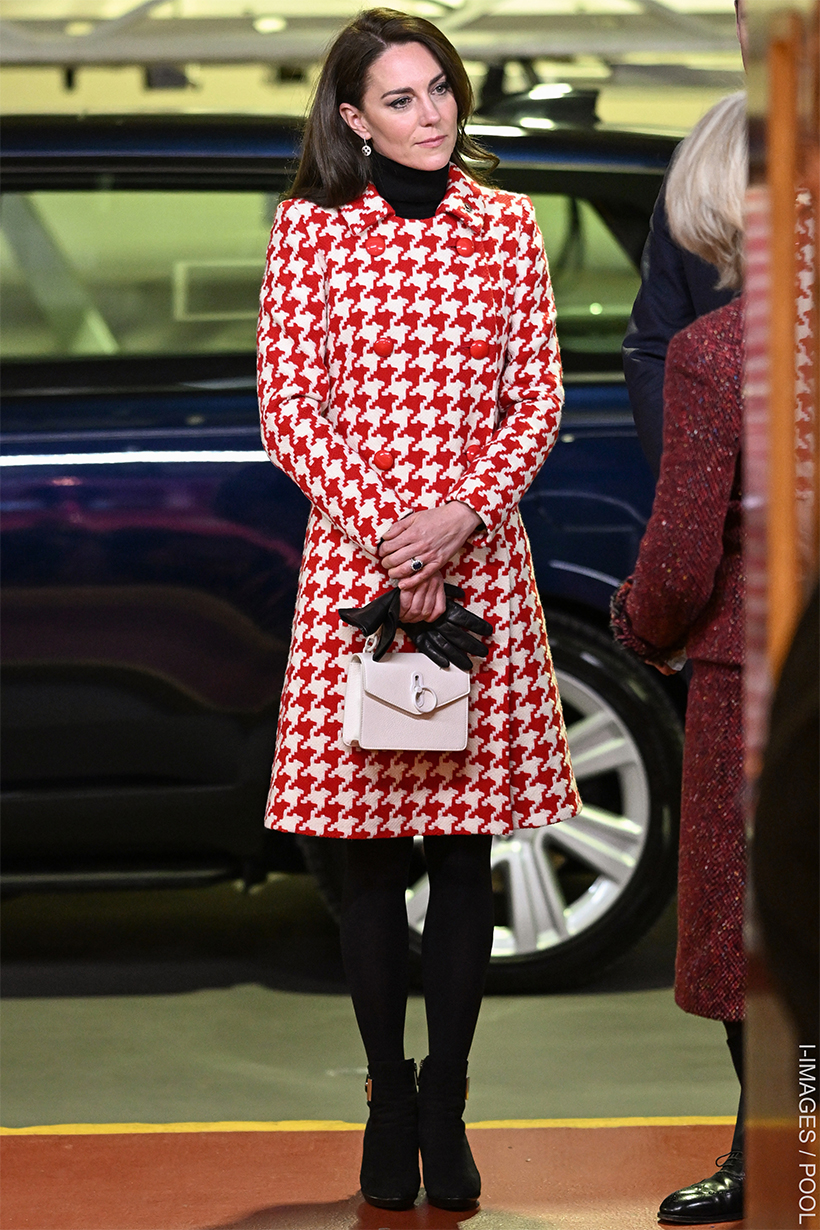 Kate Middleton in 2023, wearing her red and white houndstooth coat by Catherine Walker & Co, tailored for her post-pregnancy figure, paired with black tights, black ankle boots and a white handbag.