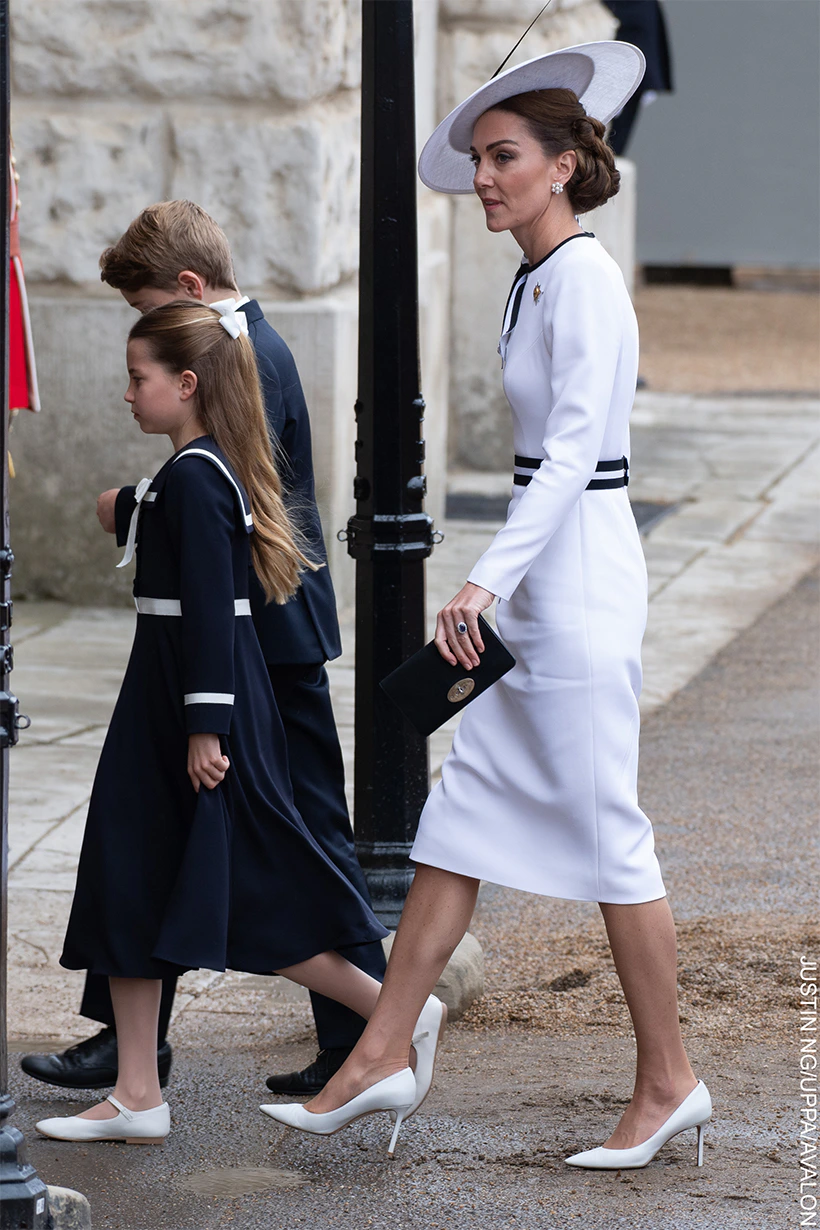 Kate looks stunning in a white dress with black trim and matching hat. 