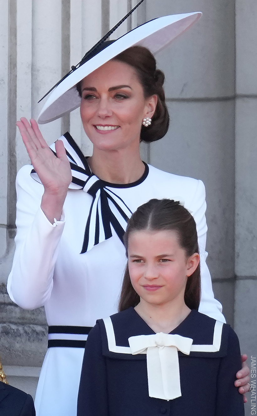 Kate Middleton on the balcony of Buckingham Palace during 2024 Trooping The Colour. The Princess wears a striking white hat, and matching white dress with black trims.